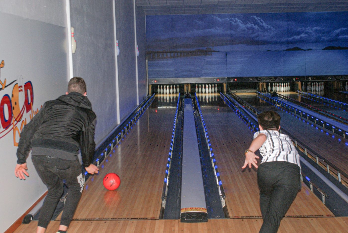 Dois jogadores a lançar a bola nas pistas do Good Bowling