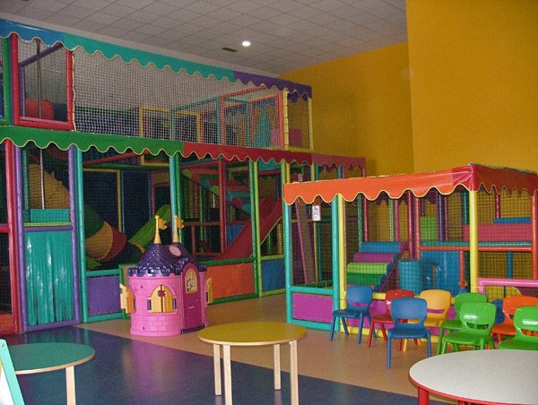 Parque infantil colorido com escorregas, casinha cor-de-rosa e cadeiras para crianças em Leiria
